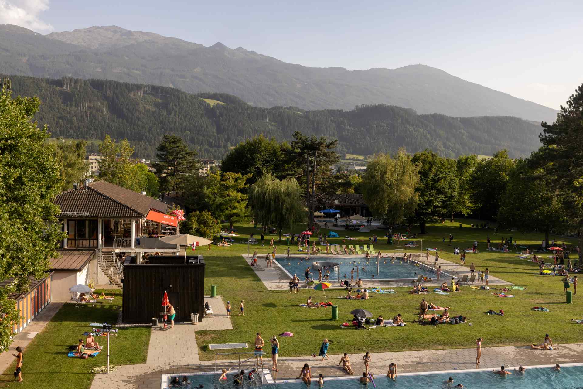 Ein Ausblick über das gut besuchte Schwimmbad an einem sonnigen Tag