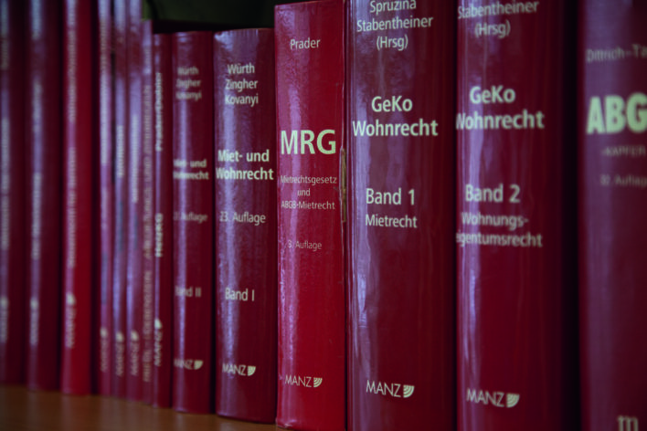 Reihe roter juristischer Fachbücher zu Miet- und Wohnrecht auf einem Regal
