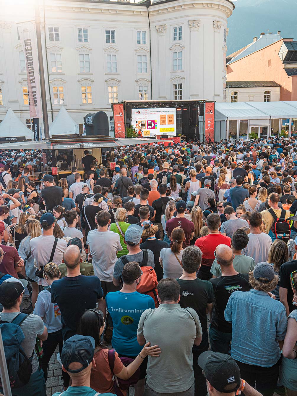 Große Menschenmenge bei dem offiziellen Race Briefing auf der Videowall vor der Hofburg Innsbruck während des Innsbruck Alpine Trailrun Festivals.