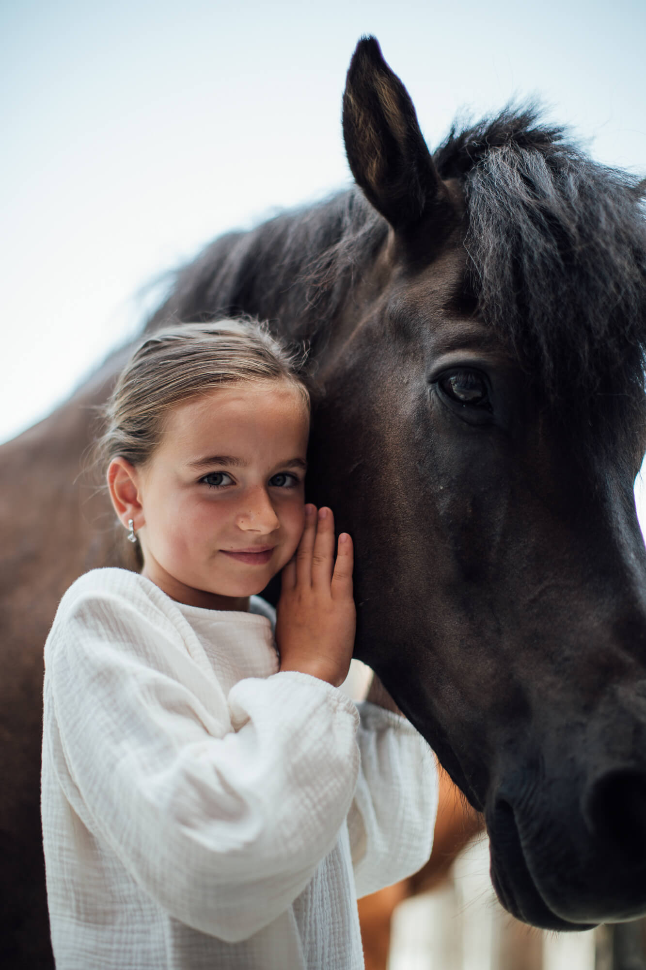 Mädchen kuschelt sich an Pferd