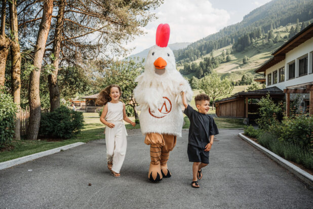 Maskottchen Gusti mit einem Mädchen und einem Jungen