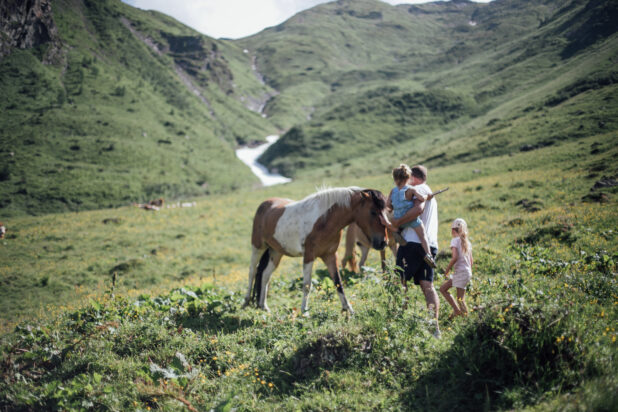 Vater mit Kindern auf der Alm bei Pferd