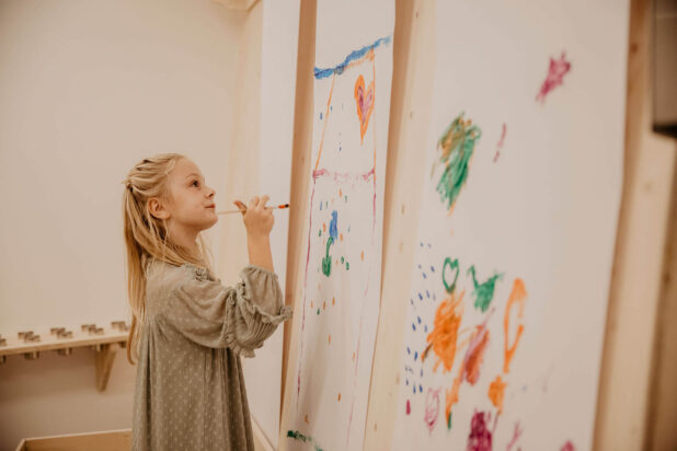 Mädchen malt im Atelier an Leinwand