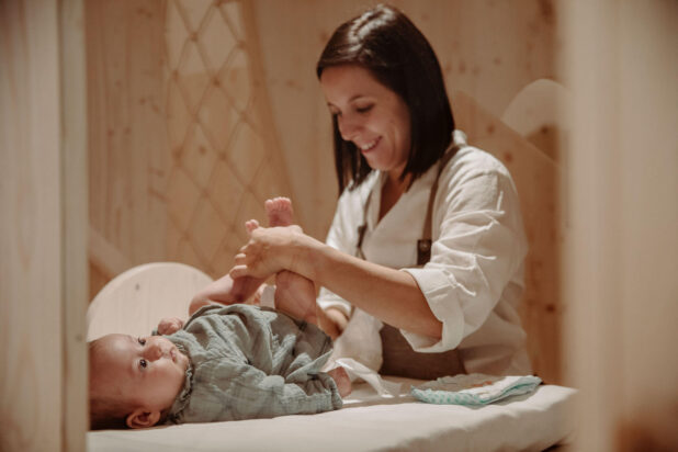 Kinderbetreuerin wickelt Baby am Moar Gut