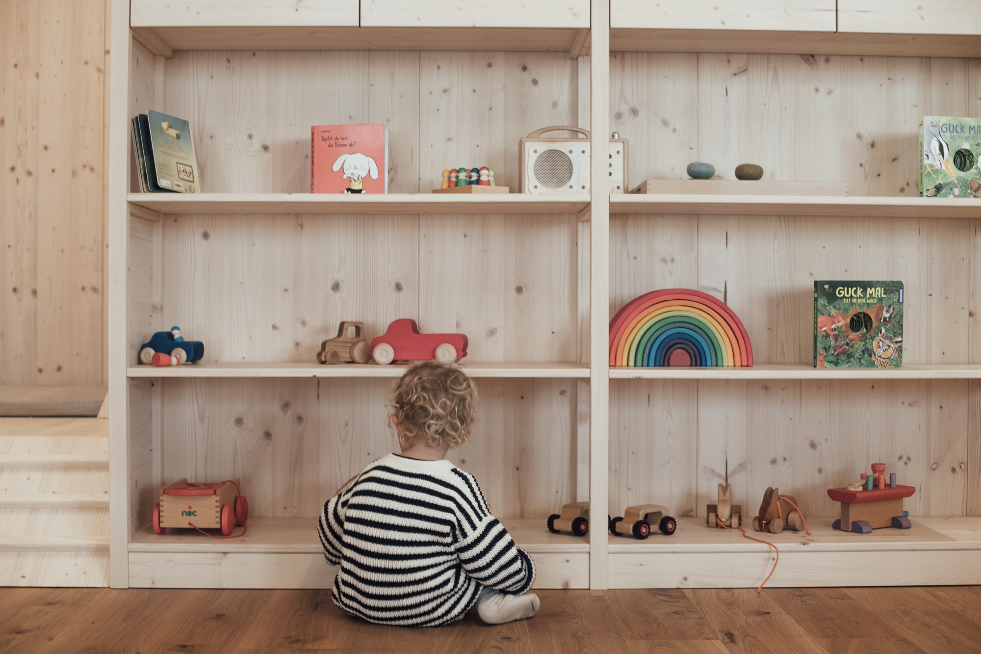 junge sitzt vor regal und spielt
