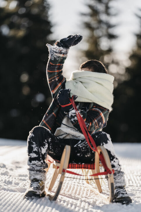 Ein Junge auf einem Schlitten im Salzburger Land