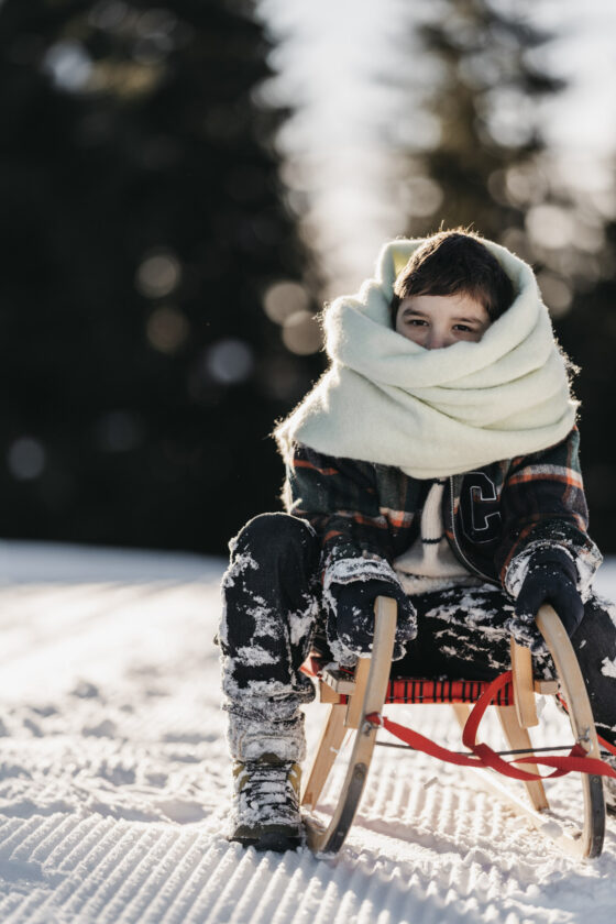 Ein Junge auf einem Schlitten im Salzburger Land