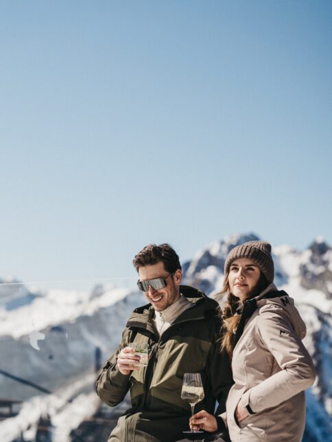 Ein Paar genießt ein Glas auf der Hütte im Snow Space Salzburg