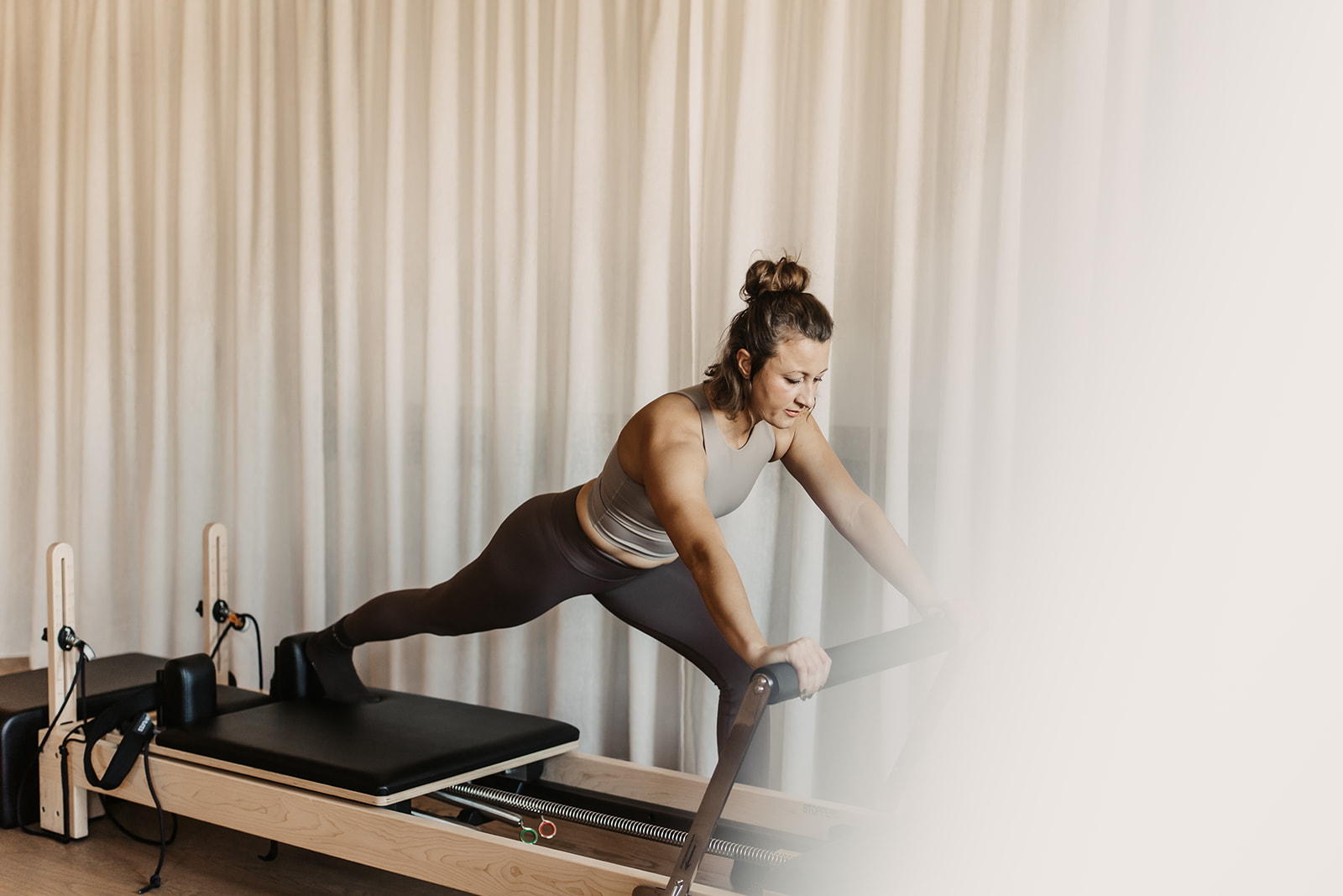 Eine Frau beim Reformer Pilates im Sporthotel Alpina Alpendorf.