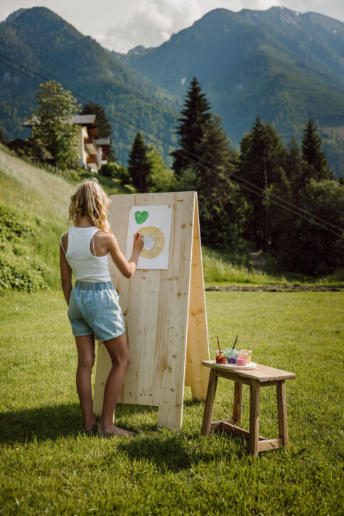 Mädchen beim Malen im Garten im Alpina Alpendorf