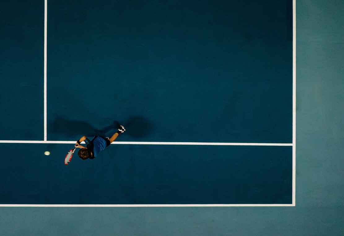 Ein Junge spielt Tennis in der Tennishalle im Alpina in Salzburg Land.