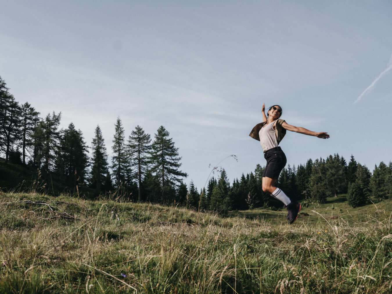 Wanderin hüpft in den Bergen in die Lüfte