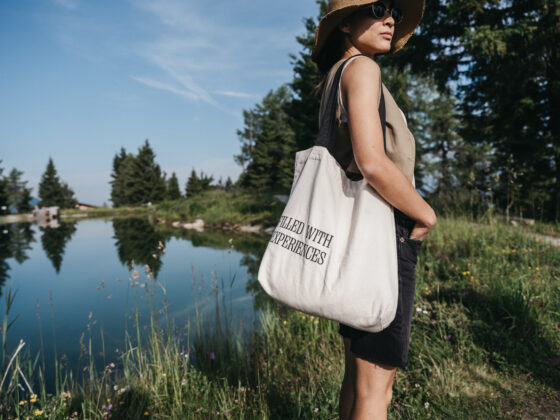 Eine Dame genießt die Aussicht auf die Berge und im Hintergrund ein Bergsee