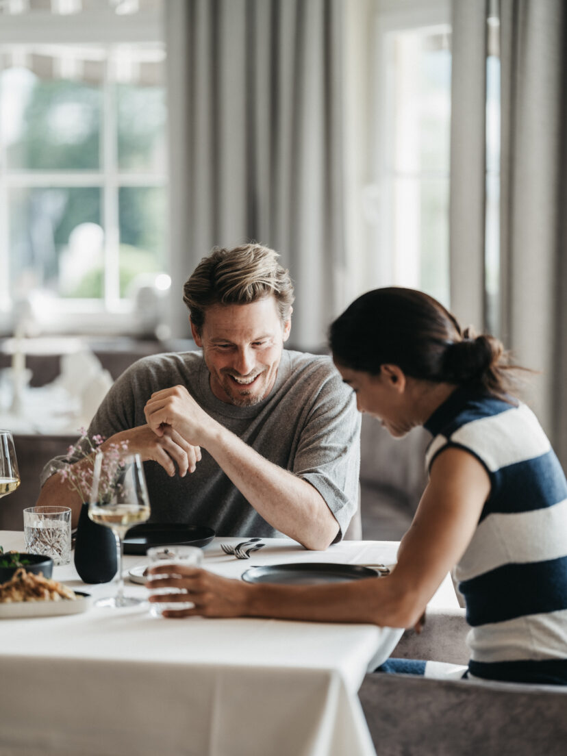 Ein Paar genießt das Dinner im Restaurant im Alpina Alpendorf im Salzburger Land