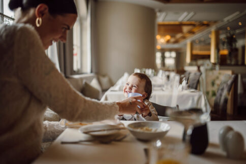 Mama und Kind beim Abendmenü am Tisch im Alpina Alpendorf