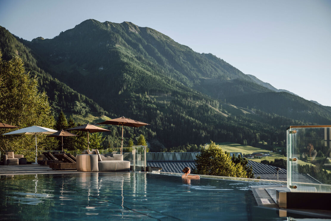 Dame genießt die Aussicht auf die Bergwelt im Alpina Alpendorf im Salzburger Land