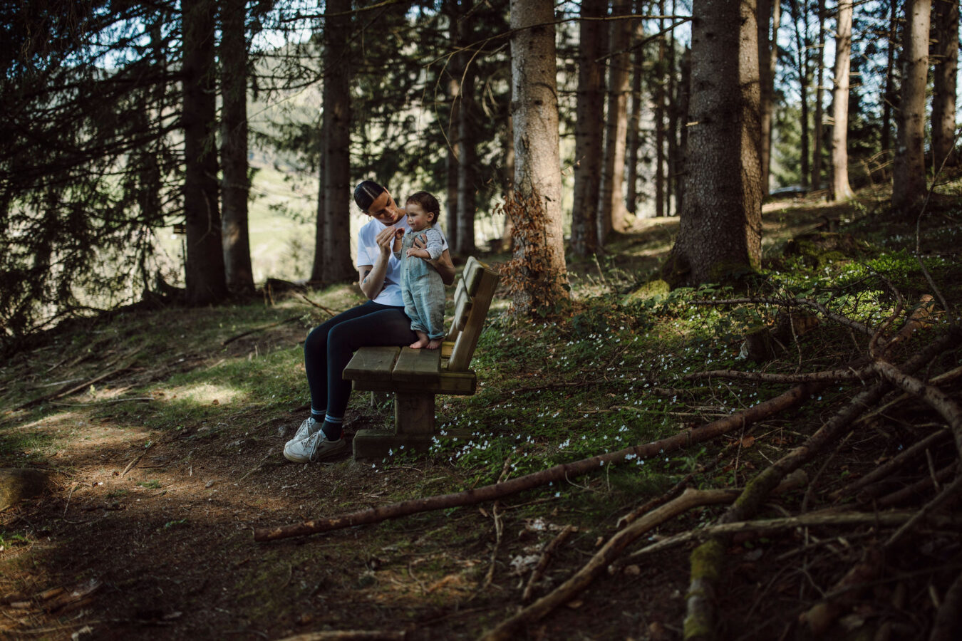 Mama genießt die Natur rund ums Alpina Alpendorf mit ihrem Baby