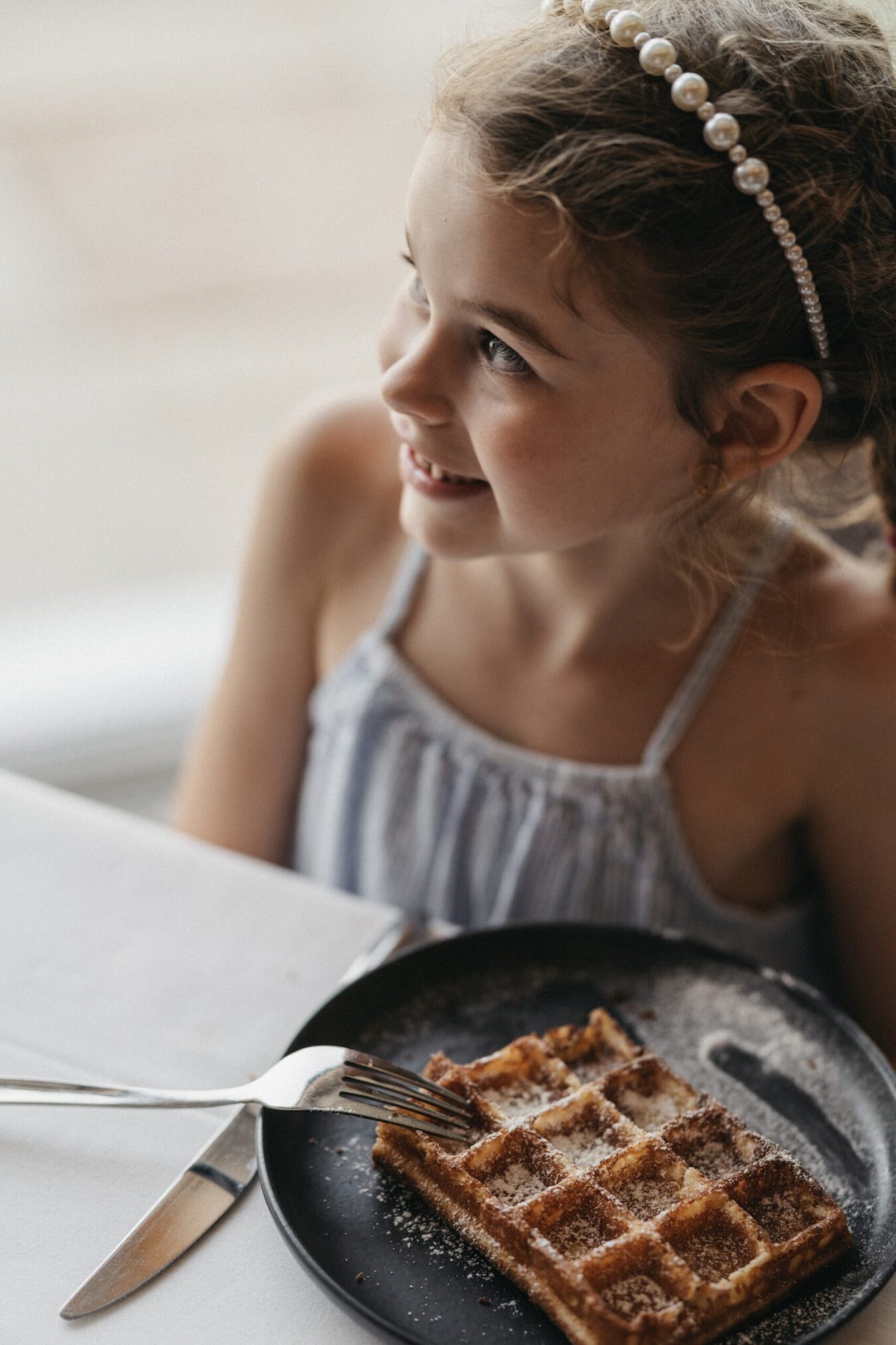 Kind beim Frühstück beim Waffeln essen im Alpina Alpendorf