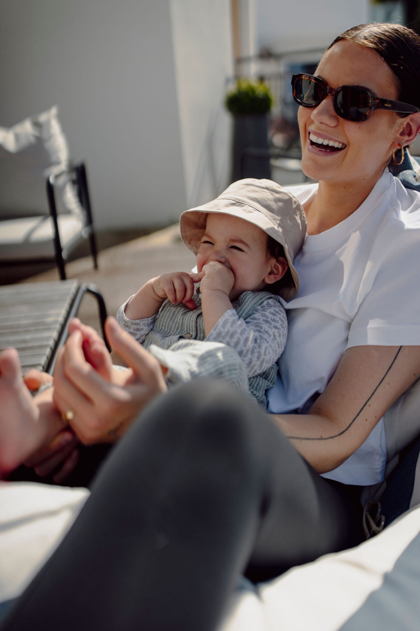 Mama und Baby genießen die Sonne auf der Terrasse im Alpina Alpendorf