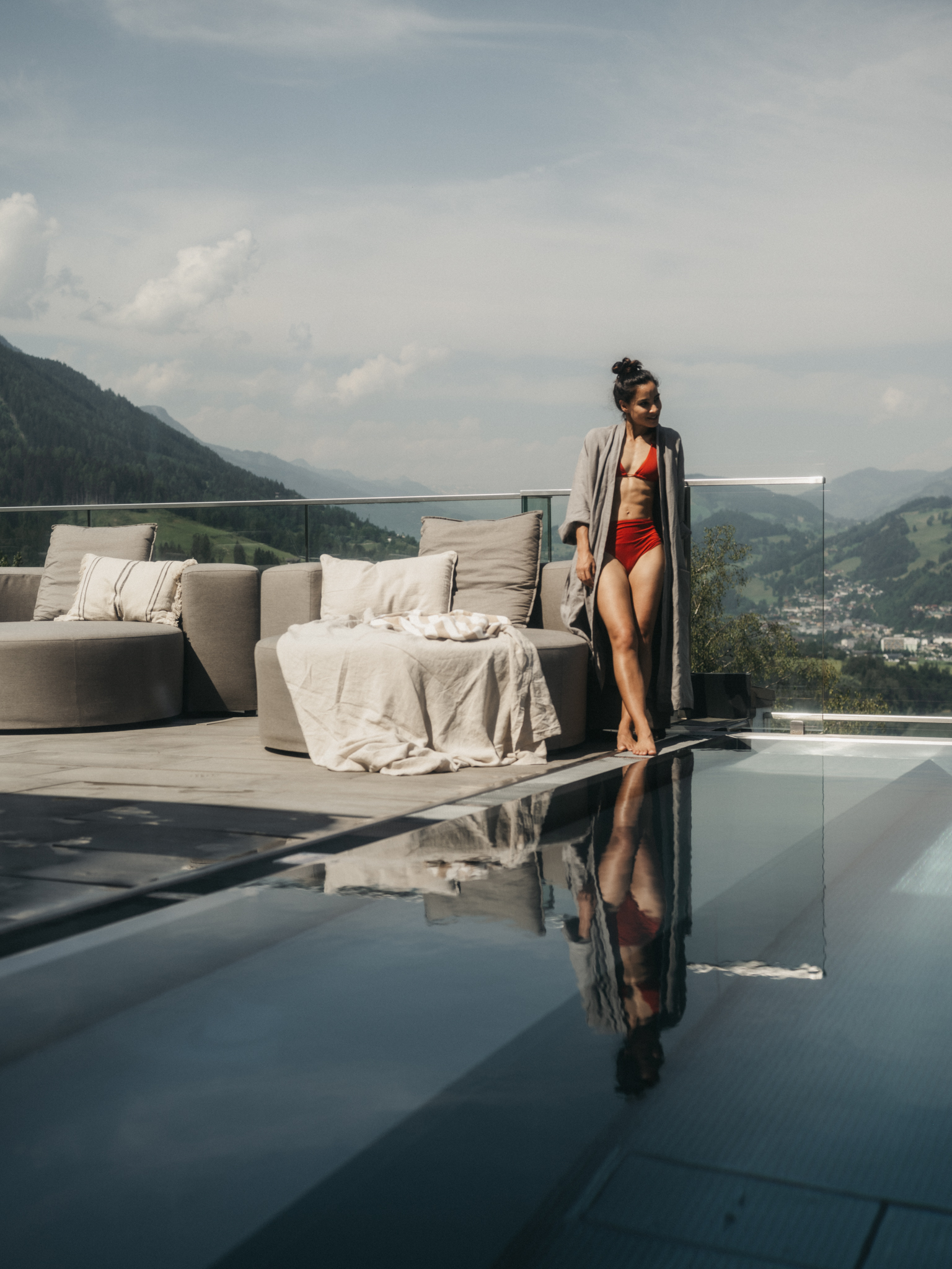 Eine Frau entspannt am Outdoor Pool vom Alpina Alpendorf der Soha Hotels.