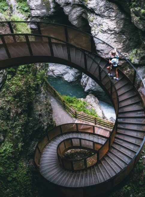 Eine Frau spaziert auf der Wendeltreppe Liechtensteinklamm in St. Johann im Pongau.