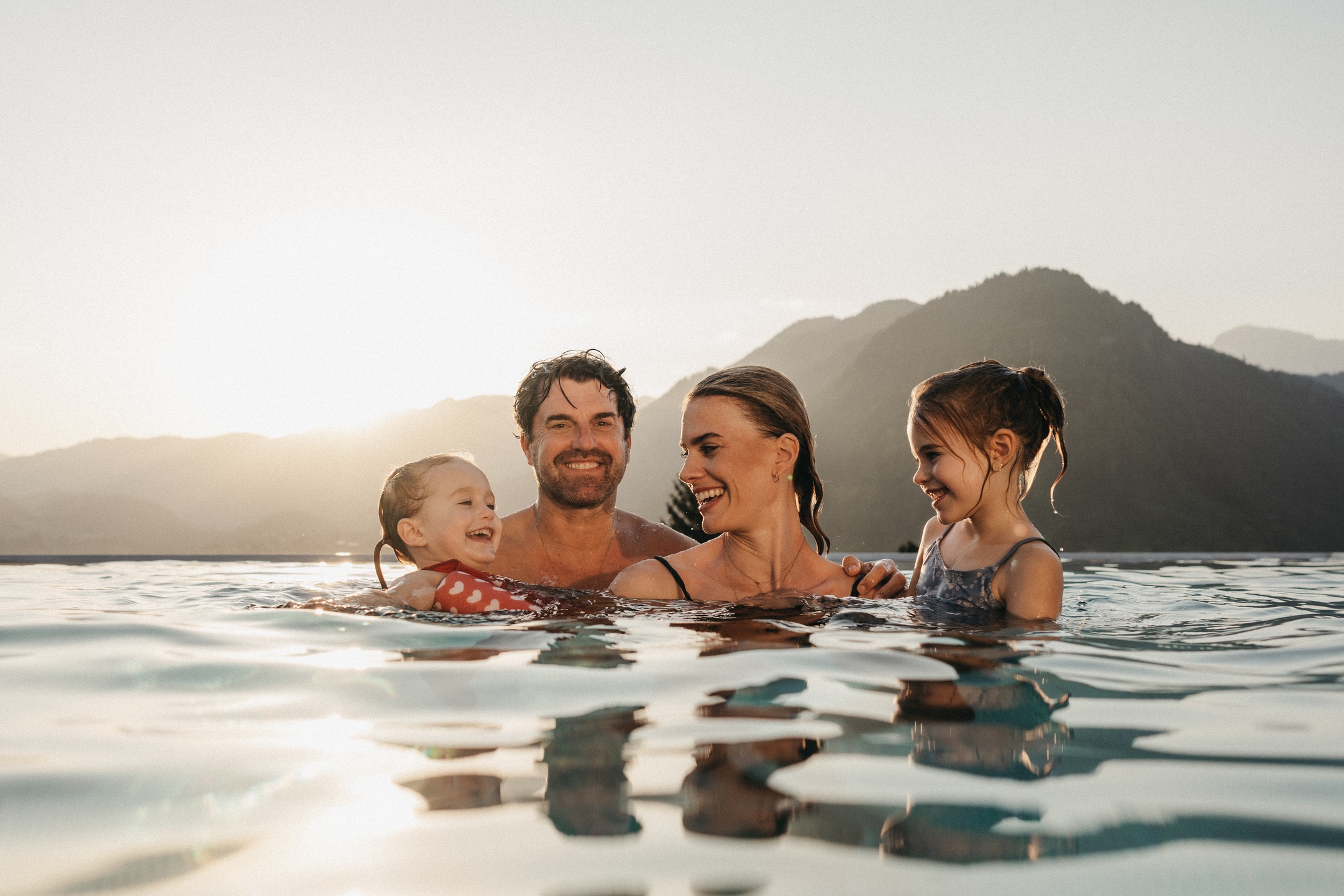 Eine Familie genießt den Urlaub im Rooftop Pool im Alpina Alpendorf