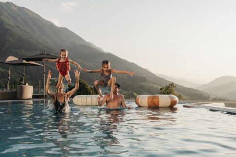 Familienurlaub im Alpina Alpendorf. Familie genießt die Zeit im Rooftop-Pool