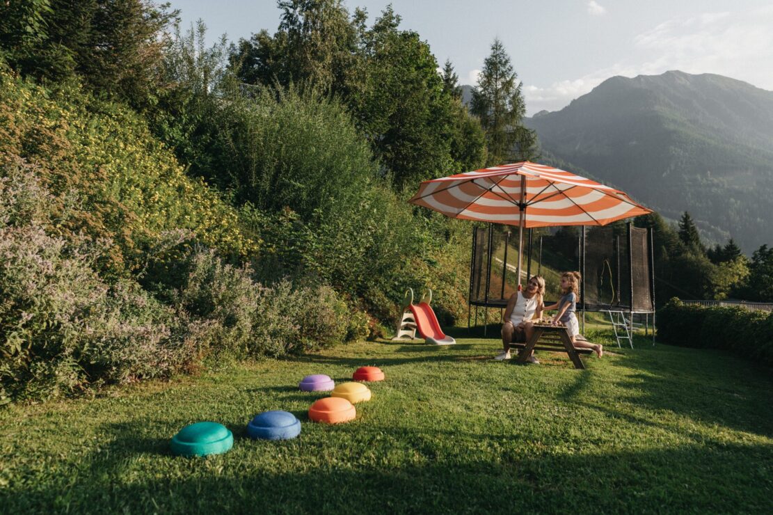 Familie am Spielplatz im Sommerurlaub im Alpina Alpendorf