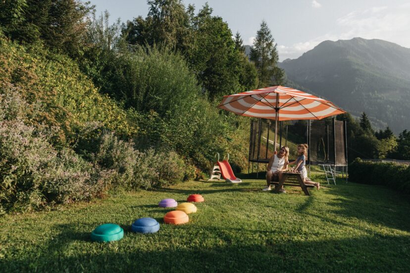 Familie am Spielplatz im Sommerurlaub im Alpina Alpendorf