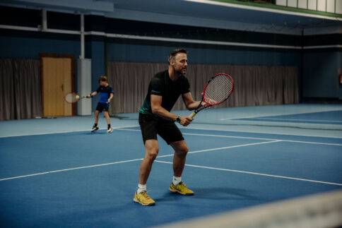 Ein Mann beim Tennis in der Tennishalle im Hotel Alpina Alpendorf direkt an der Skipiste.