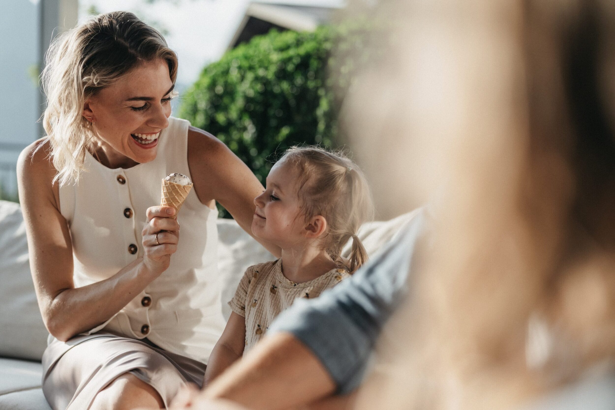 Mama und Tochter genießen das Eis auf der Terrasse im Alpina Alpendorf