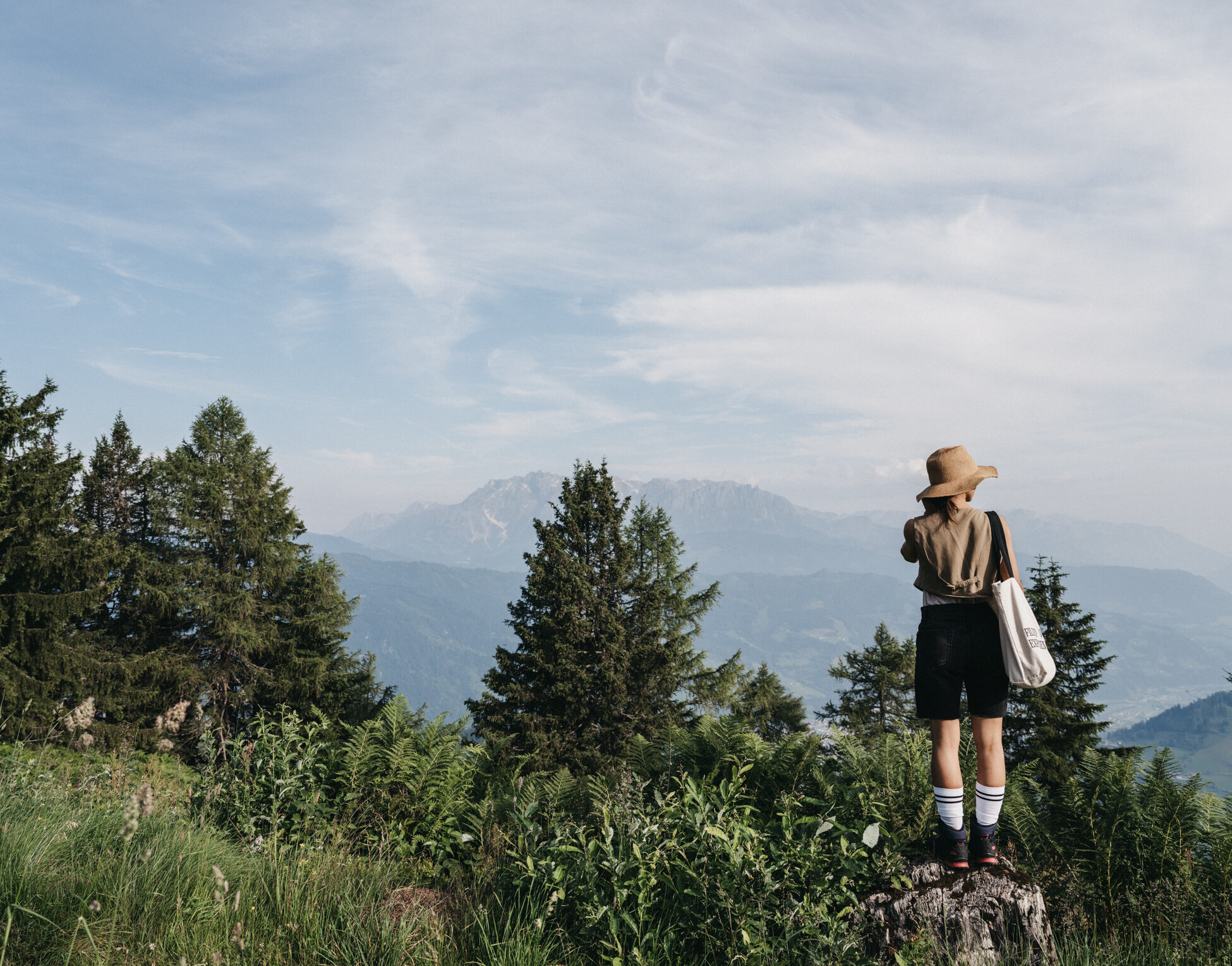 Eine Frau geniesst die Berglandschaft im Sommerurlaub in Salzburg.