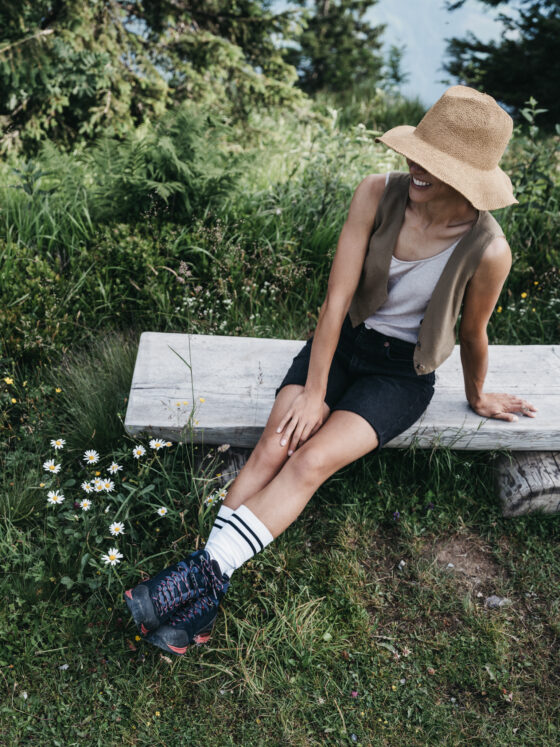 Eine Dame genießt die Aussicht auf die Berge im Alpina Alpendorf