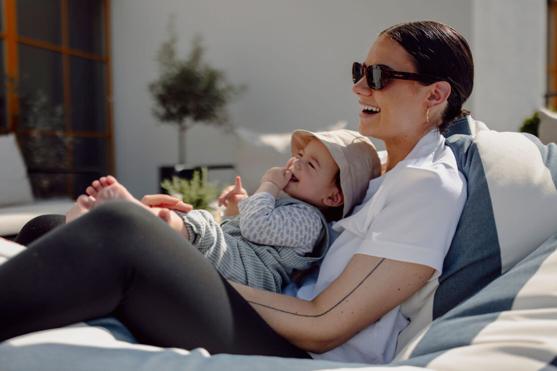 Mama und Baby genießen die Sonne auf der Terrasse im Alpina Alpendorf