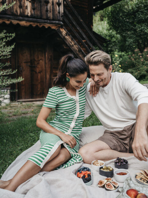 Ein Paar genießt ein Picknick im Garten vom Hotel Alpina.