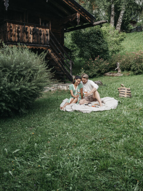 Ein Paar genießt ein Picknick im Garten vom Hotel Alpina.